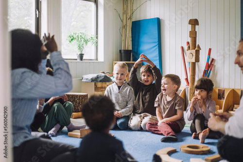 Female child care worker teaching boys and girls in day care center