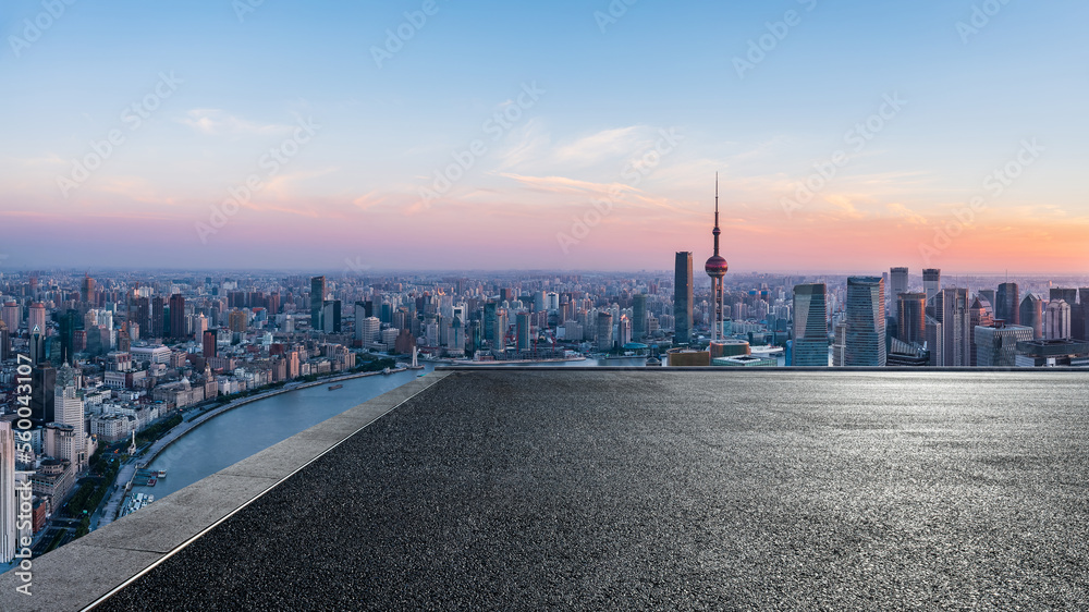 Asphalt road and city skyline with modern buildings at sunrise in Shanghai, China.