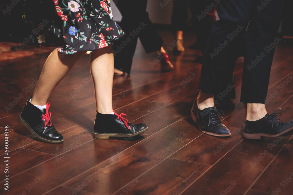 Dancing shoes of young couple dance retro jazz swing dances on a ballroom club wooden floor, close up view of shoes, female and male, dance lessons class rehearsal Dancing shoes of young couple dance retro jazz swing dances on a ballroom club wooden floor, close up view of shoes, female and male, dance lessons class rehearsal