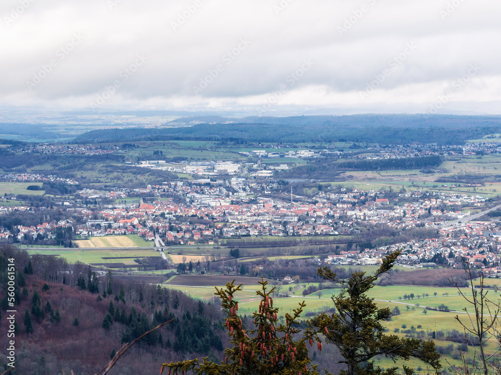 Fototapeta premium Ausblick vom Zeller Horn in Albstadt auf den kegelförmigen Zollerberg mit Burg Hohenzollern, das Tal mit Hechingen, Wessingen und Boll und am Horizont die Schwäbische Alb
