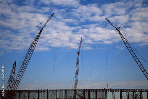 Cranes used to hoist materials at commercial construction site in USA.