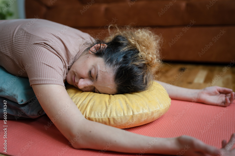 One adult caucasian woman practice restorative yoga at home One adult caucasian woman practice restorative yoga at home