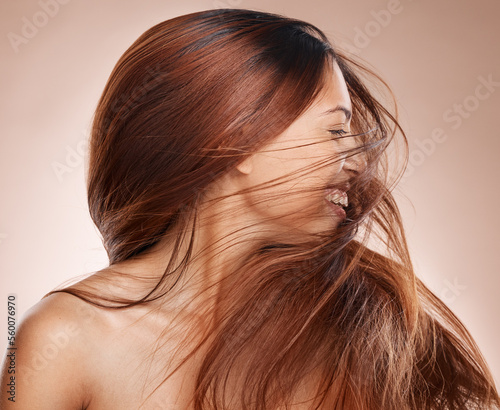 Shaking hair, beauty and cosmetics of a happy woman on studio background for luxury keratin treatment with shampoo product. Headshot of female posing for salon, hairdresser and wellness mockup