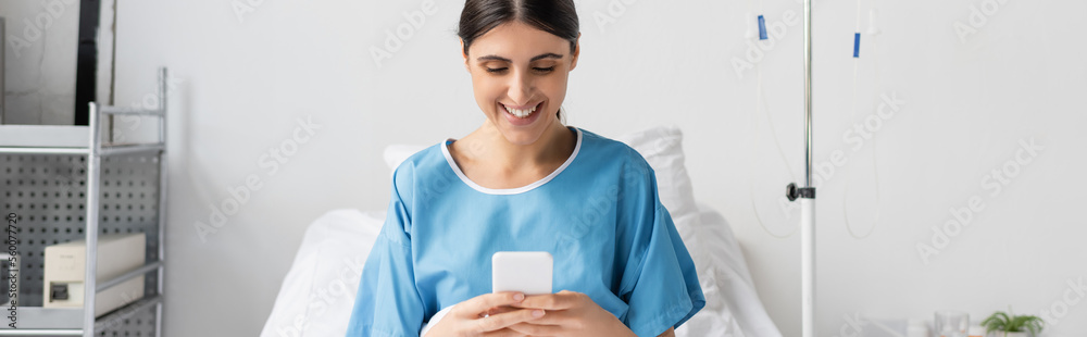 Cheerful patient using smartphone on bed in clinic, banner. - obrazy, fototapety, plakaty 