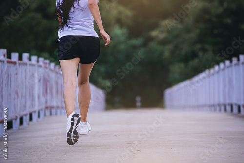 Woman jogging run on the road across the bridge. Fit woman runners, fitness running during outdoor workout.