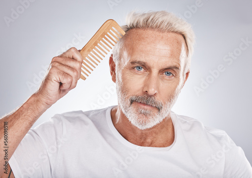 Mature man, portrait and hair comb on studio background from barbershop, salon skincare and healthy cosmetics. Face, male model and brushing hair care for fashion, shampoo product and morning routine