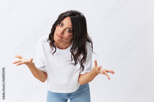 Woman in white t-shirt on white background brunette hands up gestures and signals poses in jeans emotion, lifestyle smiles, copy space