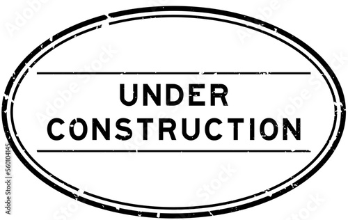 Grunge black under construction word oval rubber seal stamp on white background