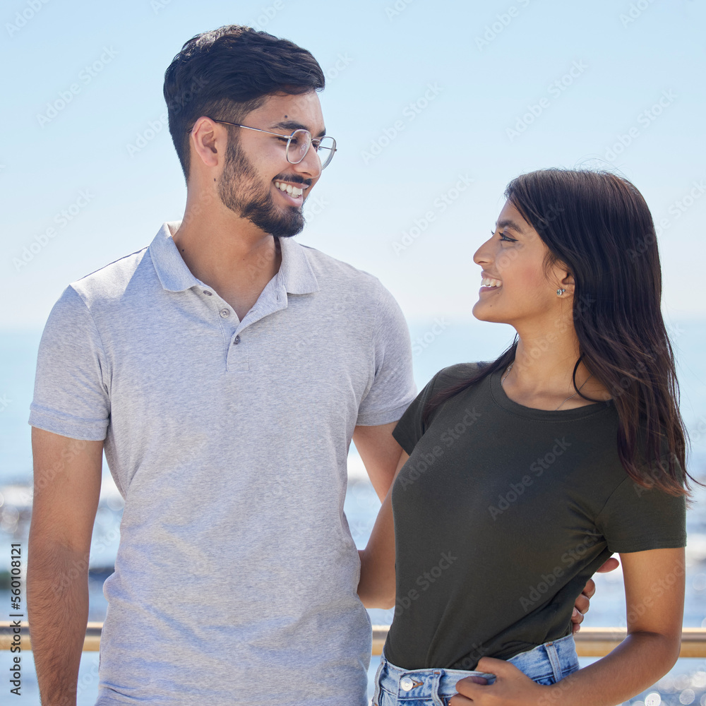 Fototapeta premium Love, hug and Indian couple with smile, bonding and loving together outdoor. Romance, man and woman on seaside holiday, break and weekend for happiness, relationship and vacation and hug in marriage