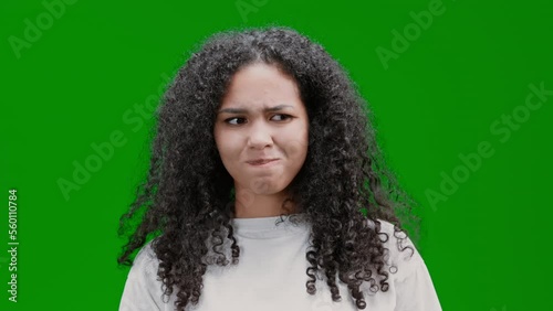 hesitant woman with curly long hair dressed white shirt has doubt worrying about problem Isolated on Green Screen