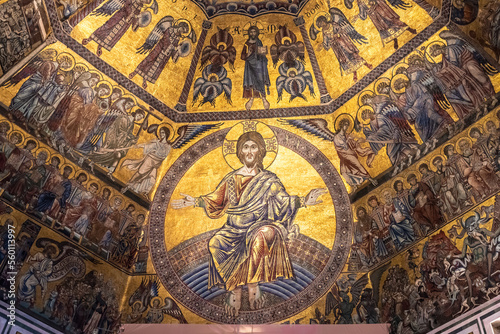 Golden mosaic composing religious mural inside catholic church in Florence showing Jesus surrounded by scenes of heaven and hell