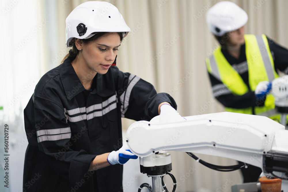 Engineer caucasian woman checking arm robot in the machine lap Engineer caucasian woman checking arm robot in the machine lap