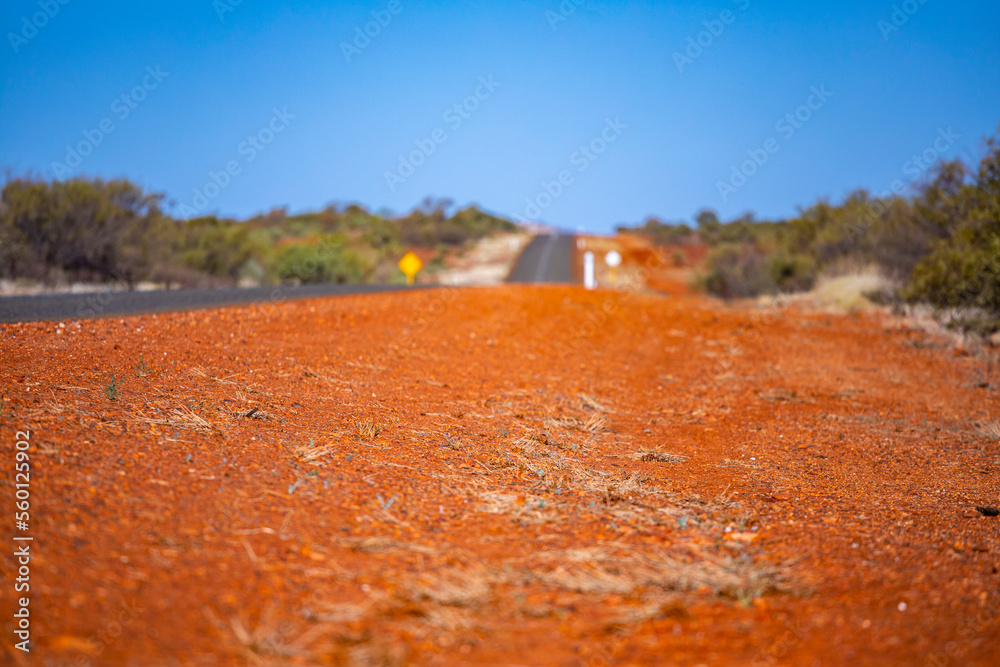 a road with a red shoulder in a remote area in karijini national park in western australia, red
