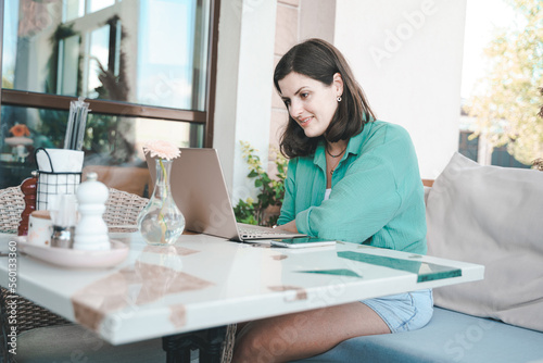 Girl,young woman with laptop.Online business meeting,interview,negotiations in cafe,restaurant. Remote work, business trip.Student studying in Internet.Education,learning.Talking with family,children