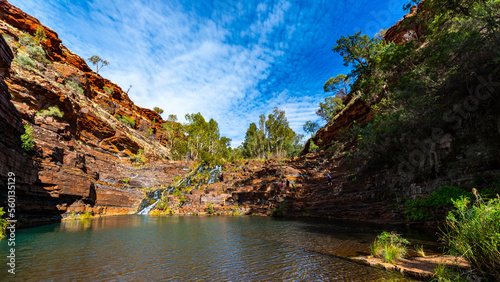 a panorama of fortescue falls in dales gorge in karijini national park in western australia; a waterfall in a lush red canyon in the desert with red sand and rocks photo