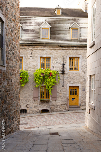 Fototapeta Naklejka Na Ścianę i Meble -  Selective focus view of beautiful stone historic 17th century house seen at the end of a narrow old town street, Petit-Champlain sector, Quebec City, Quebec, Canada