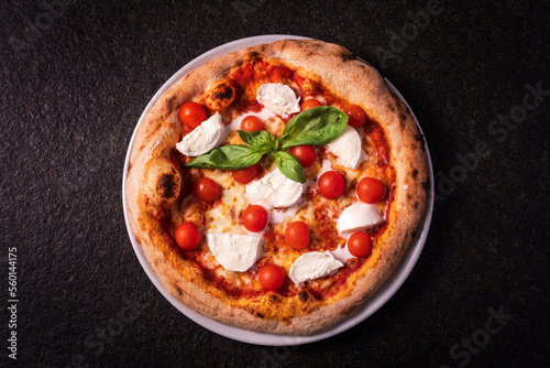 top view pizza with buffalo mozzarella and cherry tomatoes on a dark background