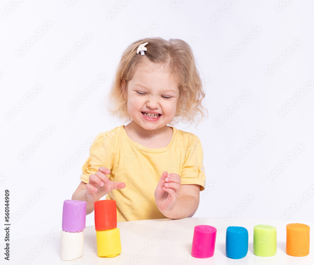 Cute little girl builds a tower from plasticine Cute little girl builds a tower from plasticine