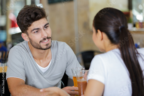 couple toasting having a beers in a bar