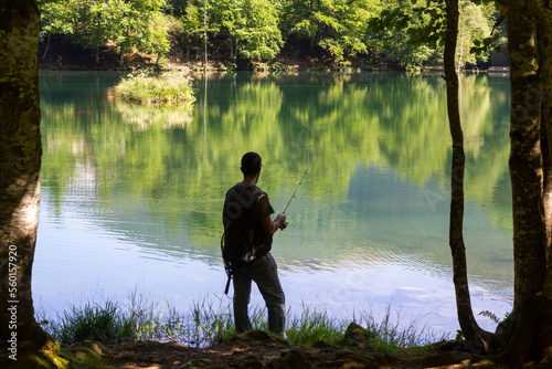 Unrecognizable fisherman catching fish from the beautiful mountain lake in Pyrenees, France