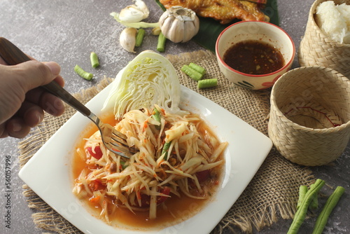 Papaya Salad, popular Thai food Served with grilled chicken, sticky rice and long beans. photo
