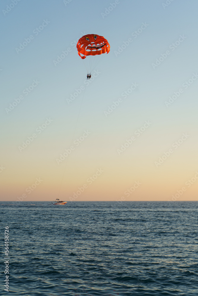 People Parasailing Over Sea Against Sky During Sunset People Parasailing Over Sea Against Sky During Sunset