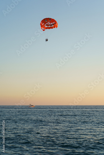 People Parasailing Over Sea Against Sky During Sunset