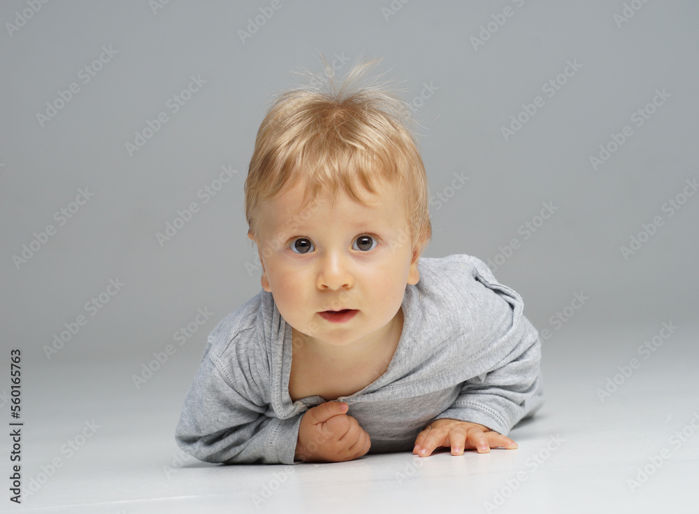 Little, happy and smiling cute baby in the studio. Portrait of a one year old baby. The concept of happiness.