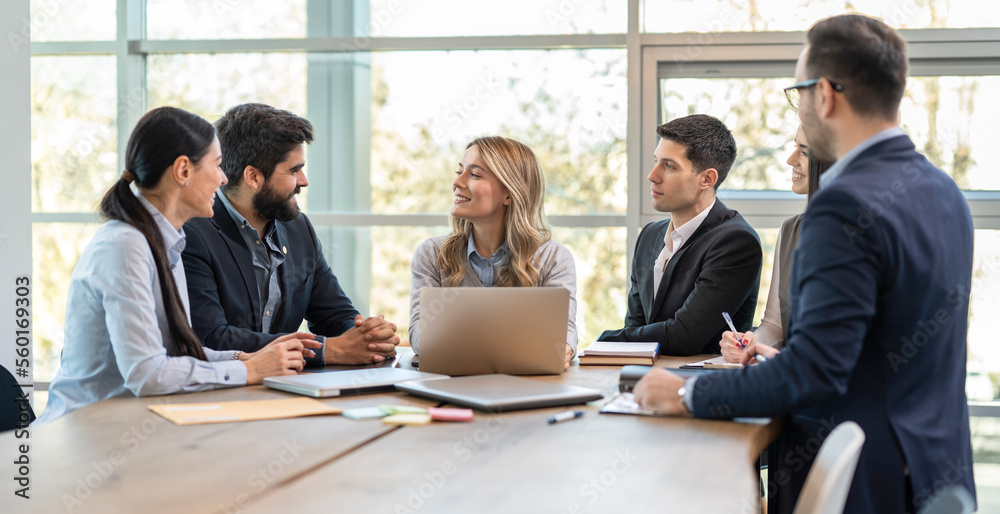 Attractive woman presenting her analysis to her diversity business team during meeting at modern office room.