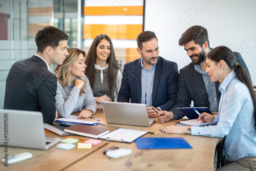 Group of diversity businesspeople working together on a laptop in conference room.