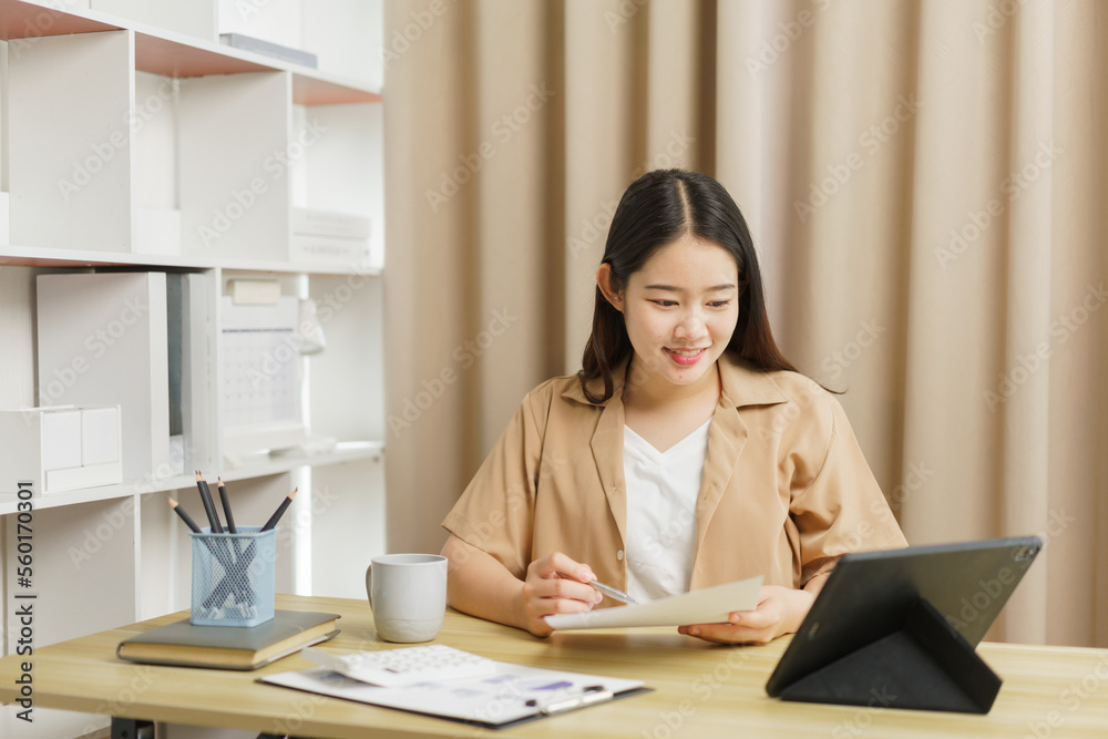 Online lifestyle concept A working woman checking some details on the document and her tablet. Online lifestyle concept A working woman checking some details on the document and her tablet.