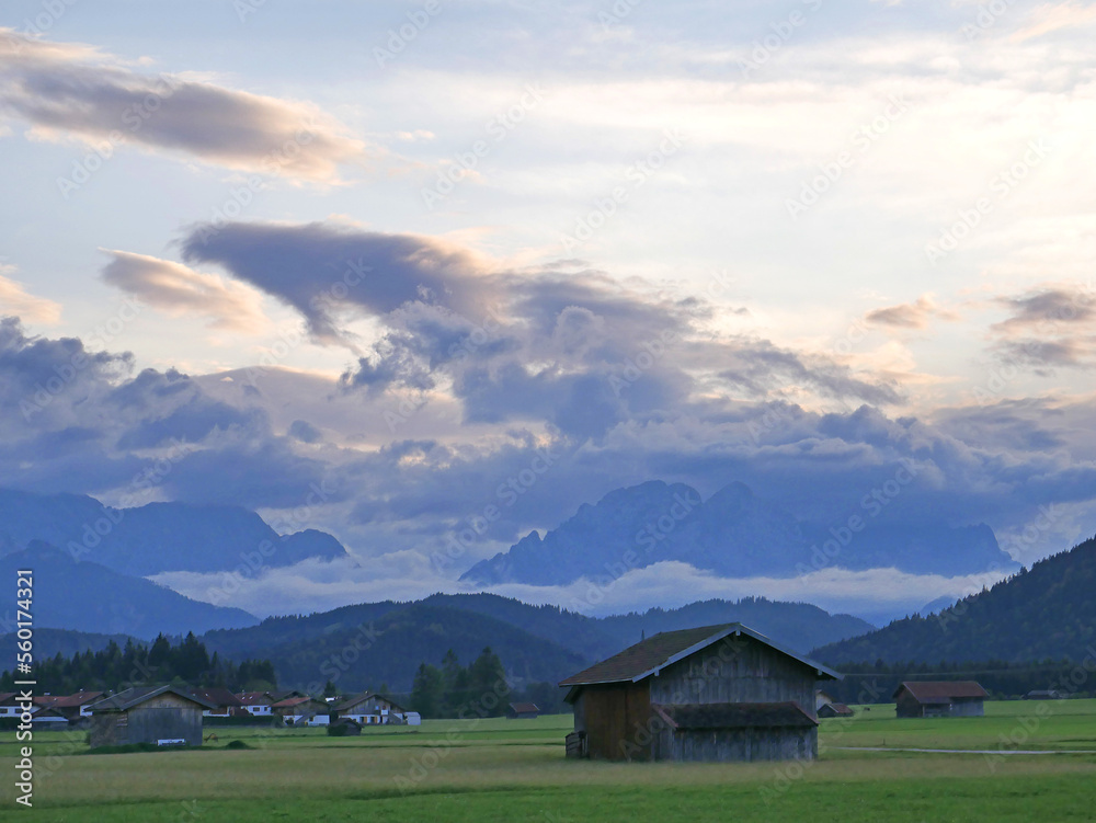 Bergwiesen bei Krün. Blick bei stürmischem Himmel auf das Wetterstein-Massiv. Bayern, Deutschland

