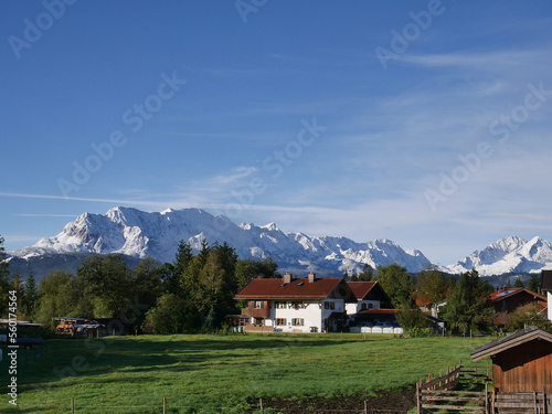 Blick über die Höfe im Isartal auf den ersten Schnee im Wettersteingebirge. Bayern, Deutschland 
