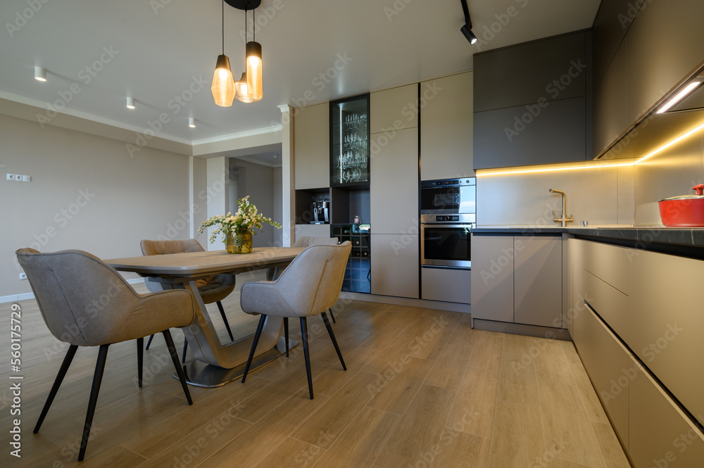 Large modern grey luxurious kitchen and dining room in studio apartment - obrazy, fototapety, plakaty 