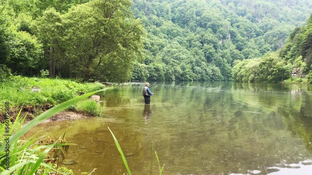 Fisherman with rod fishing on the river. Fisherman with his dog on fish. Fisherman with rod fishing on the river. Fisherman with his dog on fish.