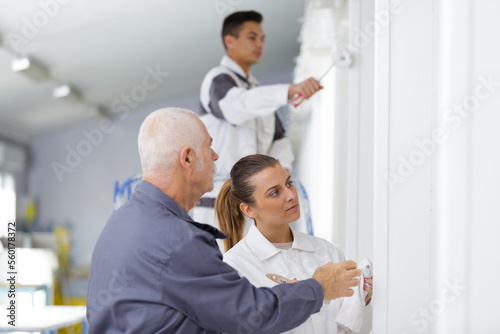 portrait of people painting wall in white
