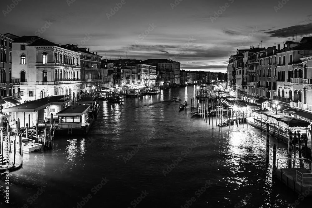 Evening cityscape in Venice, Italy; Sunset over Grand Canal from Rialto Bridge in black and white