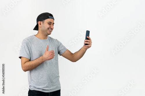 Close up photo of young boy wearing hat and using smartphone on isolated background.