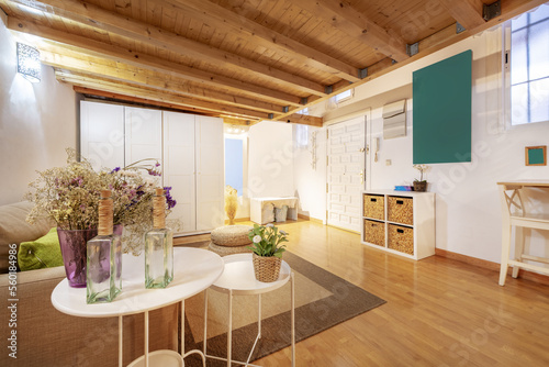 Fotografia A loft apartment with pine wood paneling and white furniture on the ground floor