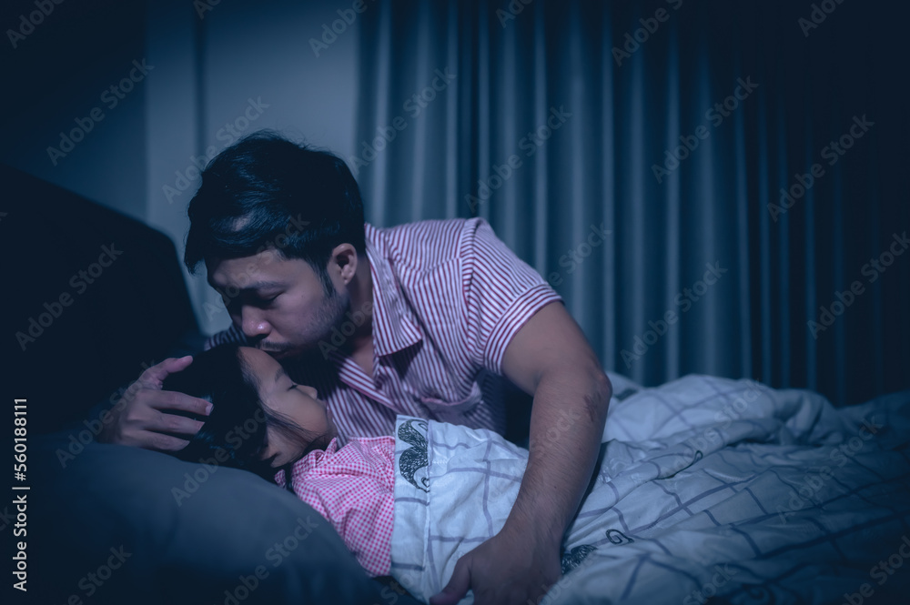 Dad and daughter sleep on the bed in bedroom,Watch cartoon with phone,Father day concept,Single dad,listen tale before sleep Dad and daughter sleep on the bed in bedroom,Watch cartoon with phone,Father day concept,Single dad,listen tale before sleep