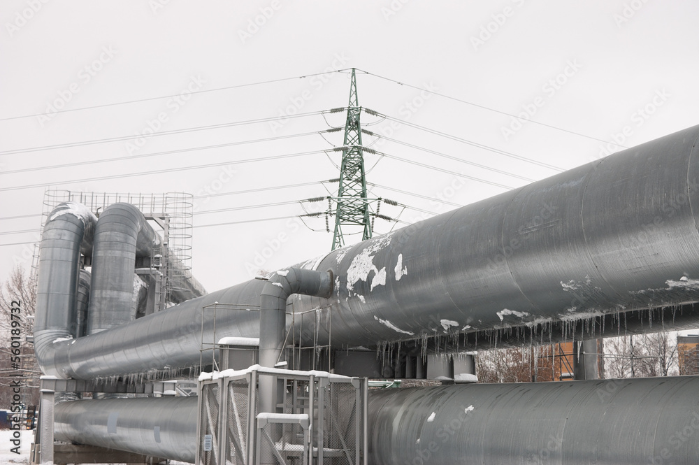 pipeline and power line in the city in winter against the gray sky pipeline and power line in the city in winter against the gray sky