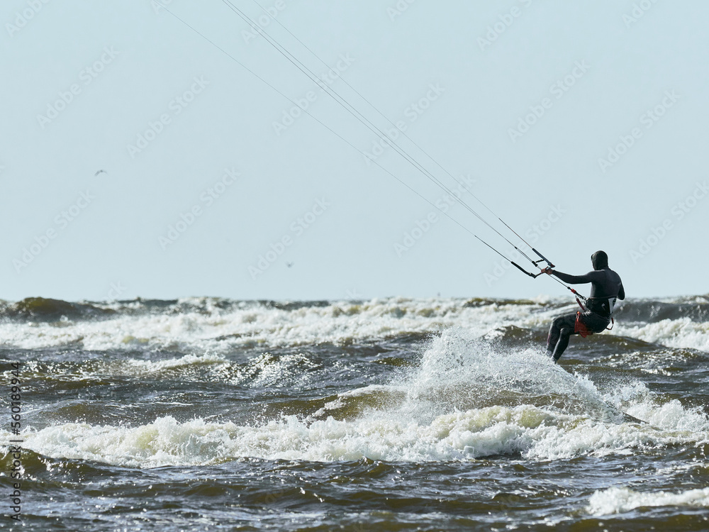 Kitesurfer carving his board across the water in a stormy sea