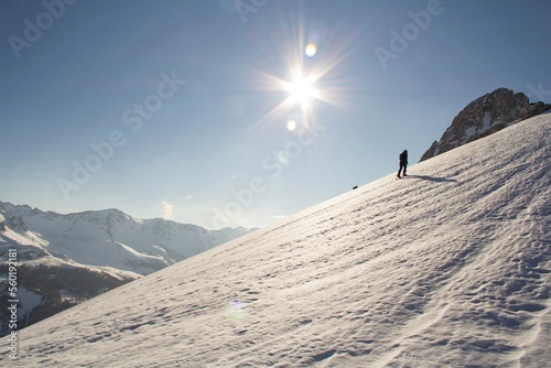 girl climbs up a snowy slope at sunset on snowshoes to reach the top of Pico Aguja, Asturias.