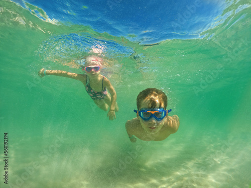 Children dive underwater at the sea on vacation. Swim and snorkeling in the sea.