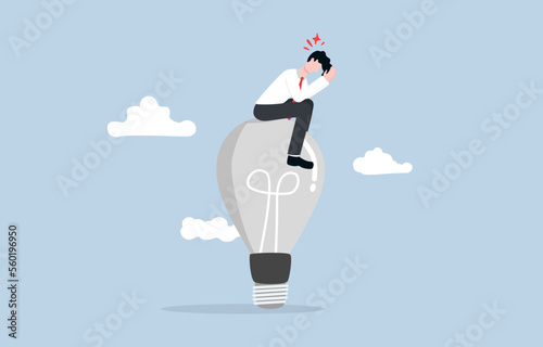 Burnout syndrome, emotional exhaustion in career, lack of creativity or new innovative idea concept, fatigued businessman sitting on old light bulb with with hands on head posture.