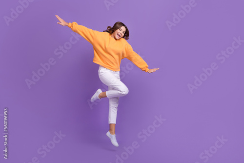 Full length portrait of cheerful excited girl jumping have fun empty space isolated on purple color background