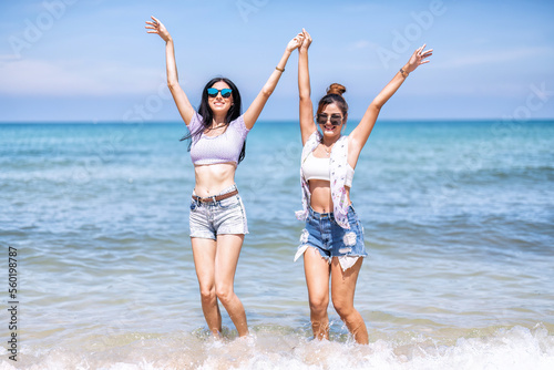 Couple LGBTQ girl on holiday happy running playing dancing along the beach on love emotion