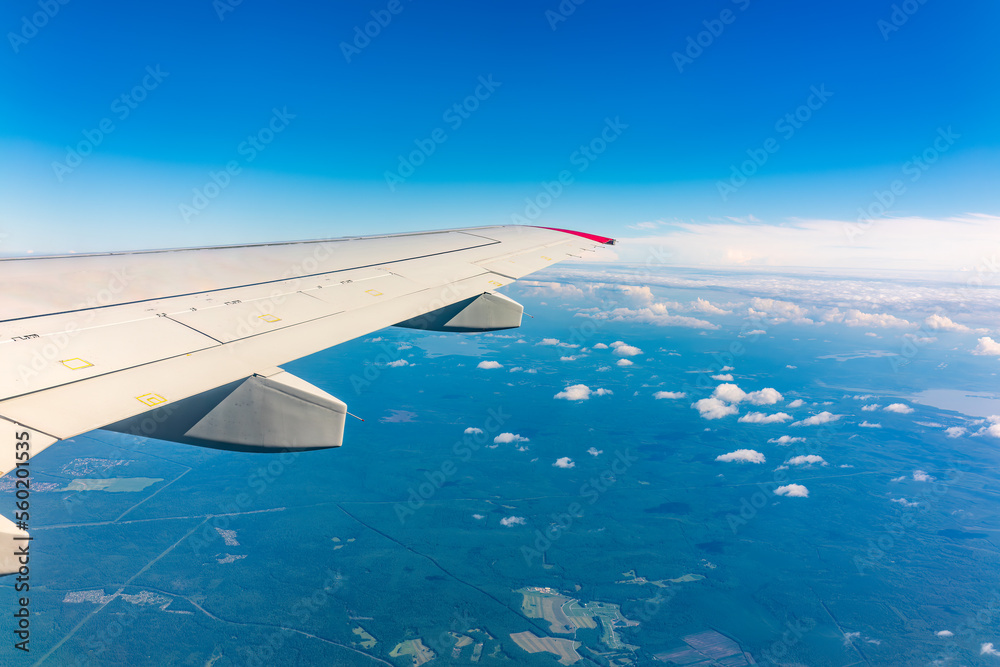 View from the airplane window at a beautiful cloudy sky and the airplane wing View from the airplane window at a beautiful cloudy sky and the airplane wing