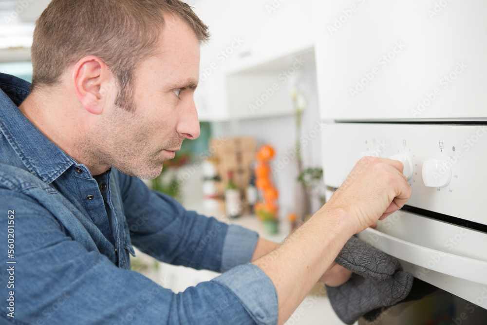 man changing temperature on the oven