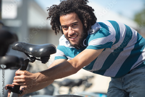young rasta man setting bicycle seat height © auremar